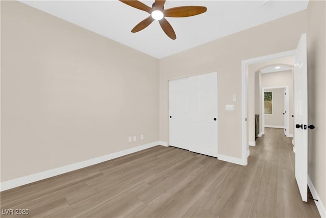 177 Rocky Star St, Henderson, NV 89012 - unfurnished bedroom with arched walkways, light wood-style floors, baseboards, and ceiling fan