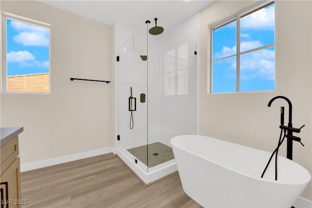 177 Rocky Star St, Henderson, NV 89012 - bathroom featuring a stall shower, vanity, a freestanding bath, wood finished floors, and baseboards