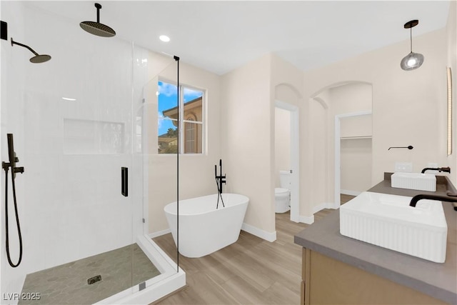 177 Rocky Star St, Henderson, NV 89012 - bathroom with a stall shower, wood finished floors, double vanity, a freestanding bath, and recessed lighting