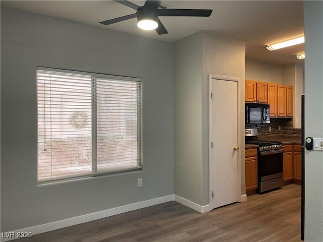 9333 Leaping Deer Pl Unit 103, Las Vegas, NV 89178 - kitchen with stainless steel range with gas stovetop, black microwave, wood finished floors, and ceiling fan