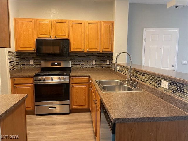 9333 Leaping Deer Pl Unit 103, Las Vegas, NV 89178 - kitchen featuring stainless steel appliances, a sink, a peninsula, decorative backsplash, and light wood finished floors
