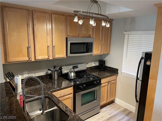 260 E Flamingo Rd Unit 228, Las Vegas, NV 89169 - kitchen with appliances with stainless steel finishes, a sink, light wood-style flooring, dark stone counters, and baseboards