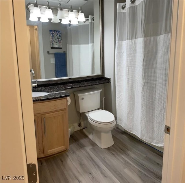 260 E Flamingo Rd Unit 228, Las Vegas, NV 89169 - bathroom featuring toilet, wood finished floors, a shower with curtain, and vanity