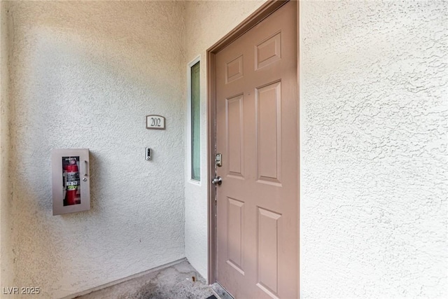 view of exterior entry with stucco siding