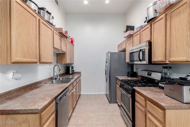 kitchen with appliances with stainless steel finishes, a sink, light brown cabinets, light tile patterned flooring, and recessed lighting