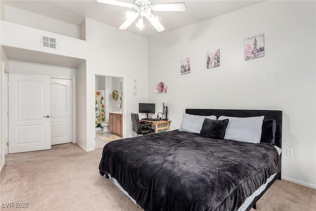 bedroom with light colored carpet, baseboards, connected bathroom, and ceiling fan