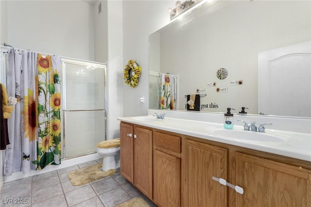 full bathroom featuring a stall shower, double vanity, toilet, and tile patterned flooring