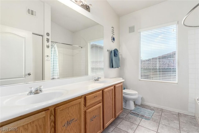 bathroom featuring toilet and double vanity