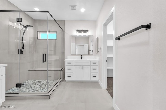 10345 Howling Coyote Ave, Las Vegas, NV 89135 - bathroom featuring vanity, a shower stall, baseboards, a walk in closet, and recessed lighting