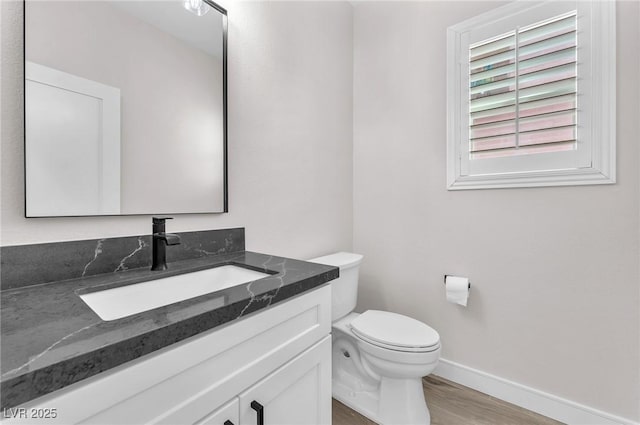 10345 Howling Coyote Ave, Las Vegas, NV 89135 - bathroom with baseboards, toilet, vanity, and wood finished floors