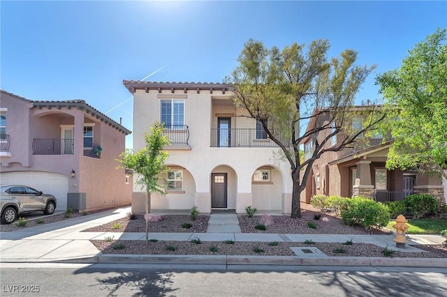 10345 Howling Coyote Ave, Las Vegas, NV 89135 - mediterranean / spanish home with stucco siding, a balcony, driveway, and a tile roof