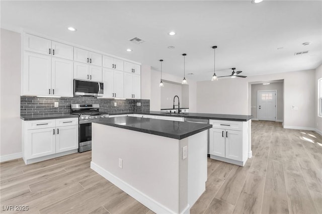 10345 Howling Coyote Ave, Las Vegas, NV 89135 - kitchen featuring appliances with stainless steel finishes, a peninsula, a sink, white cabinets, and recessed lighting