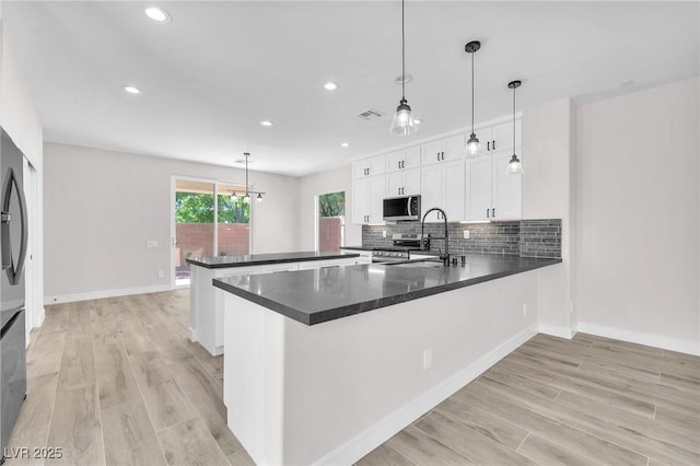 10345 Howling Coyote Ave, Las Vegas, NV 89135 - kitchen featuring stainless steel appliances, a peninsula, a sink, recessed lighting, and light wood finished floors