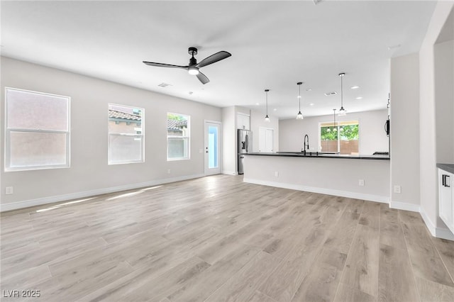 10345 Howling Coyote Ave, Las Vegas, NV 89135 - unfurnished living room featuring recessed lighting, light wood finished floors, ceiling fan, a sink, and baseboards