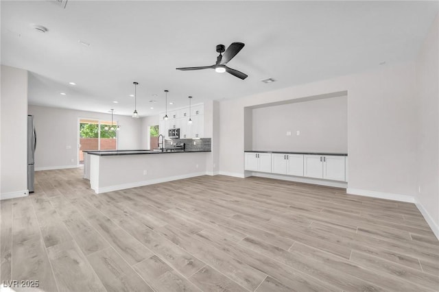 10345 Howling Coyote Ave, Las Vegas, NV 89135 - unfurnished living room featuring recessed lighting, light wood-style floors, baseboards, a sink, and ceiling fan