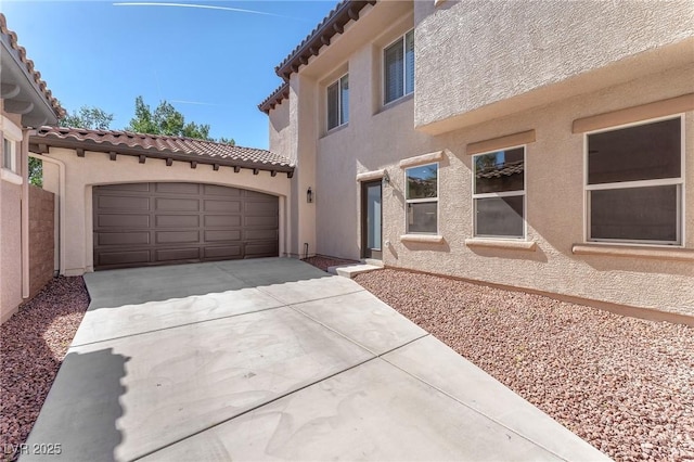 10345 Howling Coyote Ave, Las Vegas, NV 89135 - view of front of house featuring driveway, stucco siding, a tiled roof, and a garage