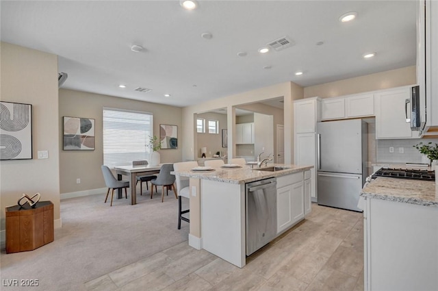 9903 Spinel Pl, Las Vegas, NV 89143 - kitchen featuring stainless steel appliances, a sink, white cabinets, a kitchen island with sink, and recessed lighting