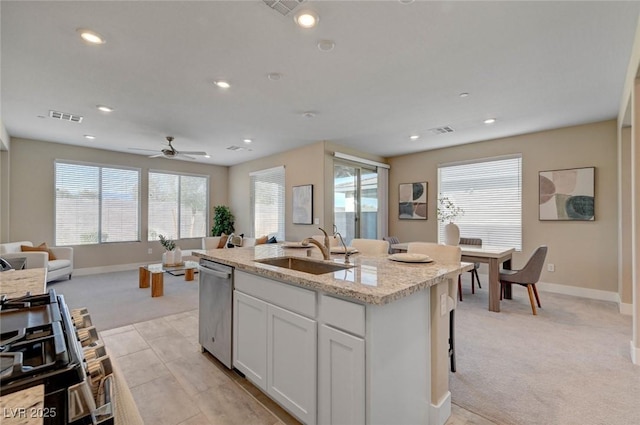 9903 Spinel Pl, Las Vegas, NV 89143 - kitchen with stainless steel dishwasher, open floor plan, a sink, light colored carpet, and baseboards