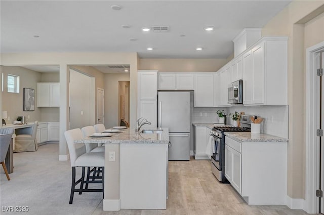 9903 Spinel Pl, Las Vegas, NV 89143 - kitchen with stainless steel appliances, white cabinetry, an island with sink, and recessed lighting