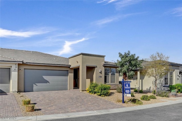 9903 Spinel Pl, Las Vegas, NV 89143 - view of front of property with stucco siding, decorative driveway, and a garage