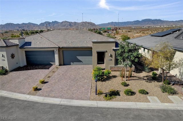 9903 Spinel Pl, Las Vegas, NV 89143 - view of front of property with a garage, a mountain view, stucco siding, and decorative driveway