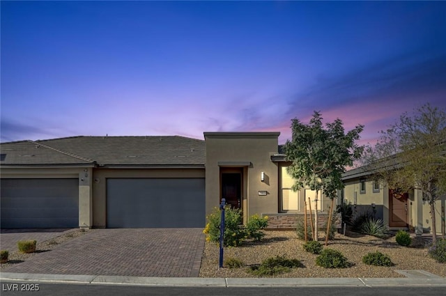 9903 Spinel Pl, Las Vegas, NV 89143 - view of front of house featuring an attached garage, decorative driveway, and stucco siding