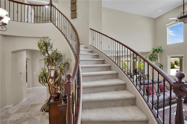 9046 Barium Rock Ave, Las Vegas, NV 89143 - staircase with a towering ceiling, arched walkways, baseboards, and a chandelier