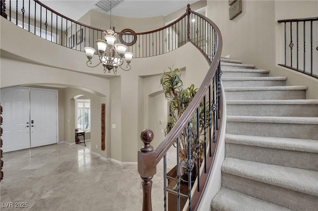 9046 Barium Rock Ave, Las Vegas, NV 89143 - foyer with arched walkways, a chandelier, stairs, a high ceiling, and marble finish floors