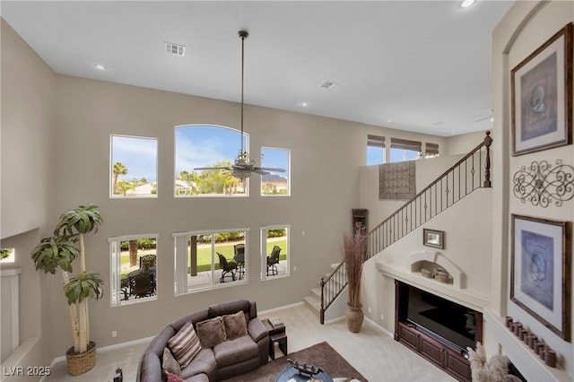 9046 Barium Rock Ave, Las Vegas, NV 89143 - carpeted living area with stairs, a ceiling fan, a high ceiling, recessed lighting, and baseboards