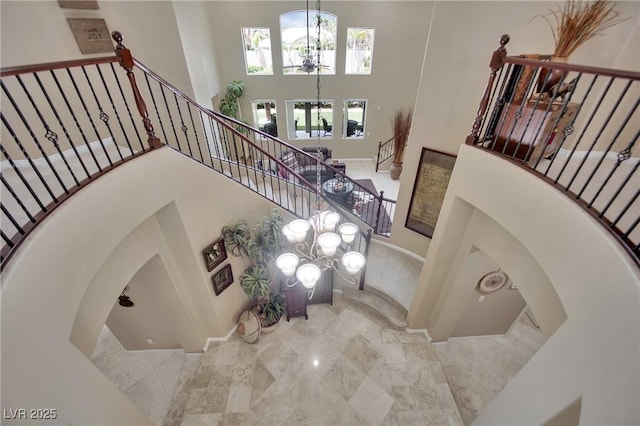 9046 Barium Rock Ave, Las Vegas, NV 89143 - stairway featuring a towering ceiling, arched walkways, a chandelier, and marble tiled flooring