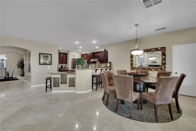 9046 Barium Rock Ave, Las Vegas, NV 89143 - dining area with arched walkways, a chandelier, recessed lighting, and baseboards