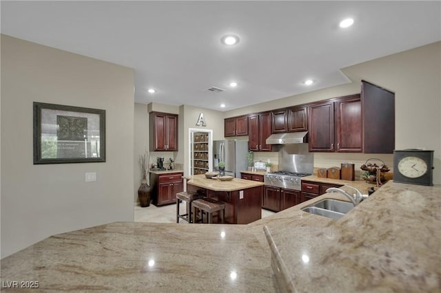 9046 Barium Rock Ave, Las Vegas, NV 89143 - kitchen with stainless steel appliances, under cabinet range hood, a sink, light stone counters, and recessed lighting