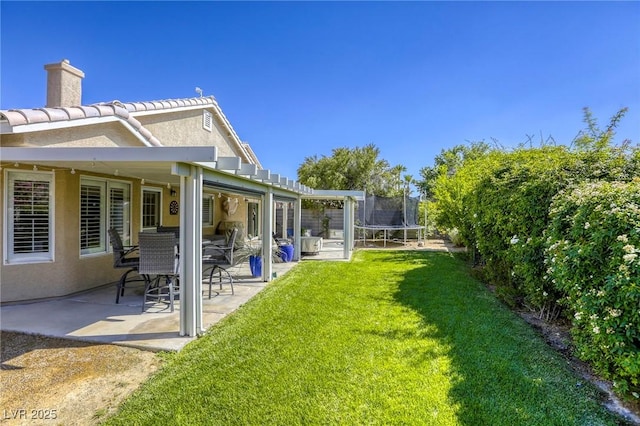 6021 Winter Meadow St, Las Vegas, NV 89130 - view of green lawn with a trampoline and a patio area