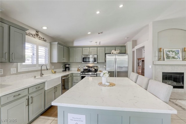 6021 Winter Meadow St, Las Vegas, NV 89130 - kitchen with appliances with stainless steel finishes, a sink, a kitchen island, gray cabinets, and light stone countertops