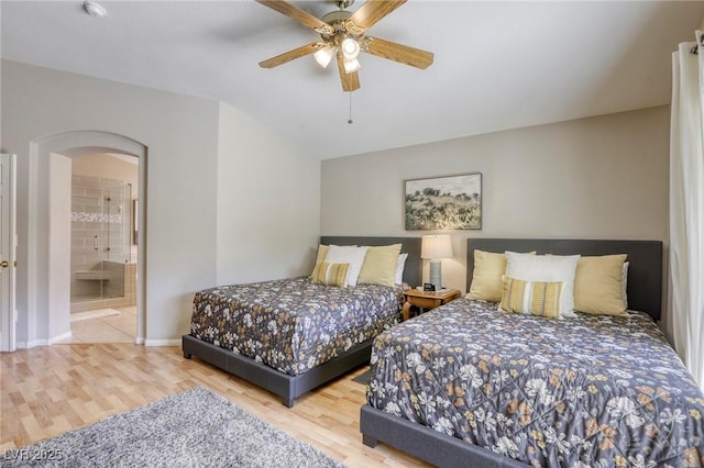 6021 Winter Meadow St, Las Vegas, NV 89130 - bedroom featuring arched walkways, wood finished floors, baseboards, ceiling fan, and connected bathroom