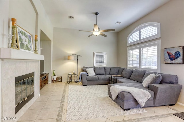 6021 Winter Meadow St, Las Vegas, NV 89130 - living room featuring light tile patterned floors, inlaid floor details, ceiling fan, a fireplace, and a high ceiling