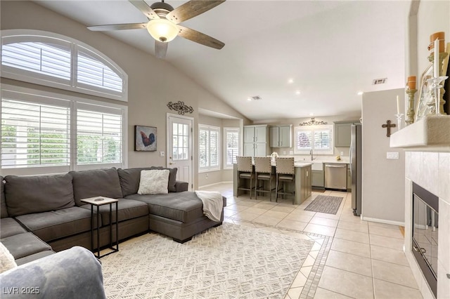 6021 Winter Meadow St, Las Vegas, NV 89130 - living area featuring light tile patterned flooring, baseboards, lofted ceiling, a ceiling fan, and a tiled fireplace