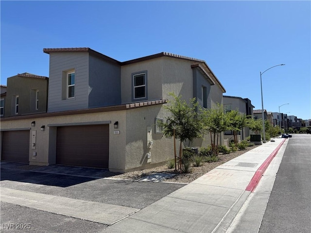 1906 Arietta Vista St, Henderson, NV 89044 - view of front facade with stucco siding, a residential view, a garage, and a tiled roof