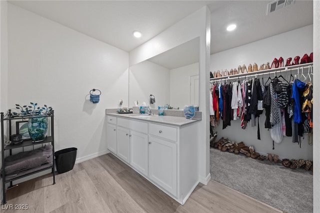2729 Pavehawk Way, Las Vegas, NV 89156 - bathroom featuring wood finished floors, vanity, and a walk in closet