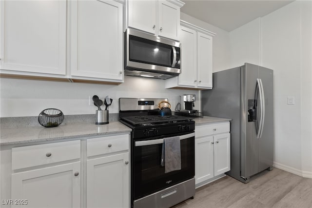 2729 Pavehawk Way, Las Vegas, NV 89156 - kitchen featuring appliances with stainless steel finishes, light wood finished floors, white cabinets, and light stone countertops