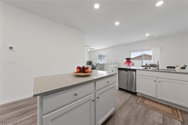 2729 Pavehawk Way, Las Vegas, NV 89156 - kitchen featuring dishwasher, light wood finished floors, a sink, white cabinetry, and recessed lighting