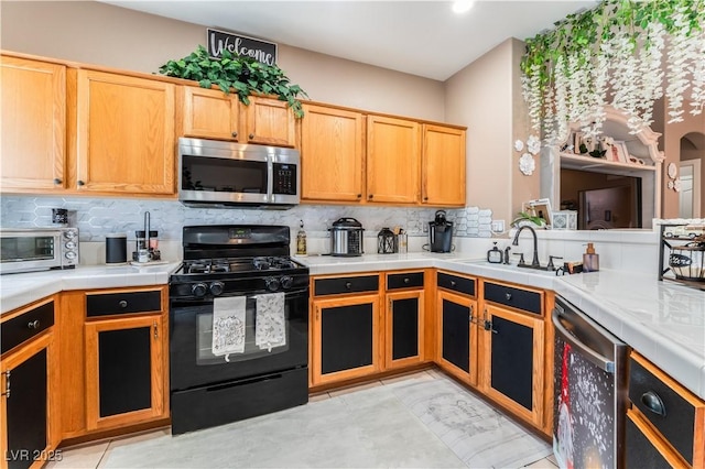 10701 Windrose Point Ave, Las Vegas, NV 89144 - kitchen with appliances with stainless steel finishes, backsplash, tile counters, and a sink