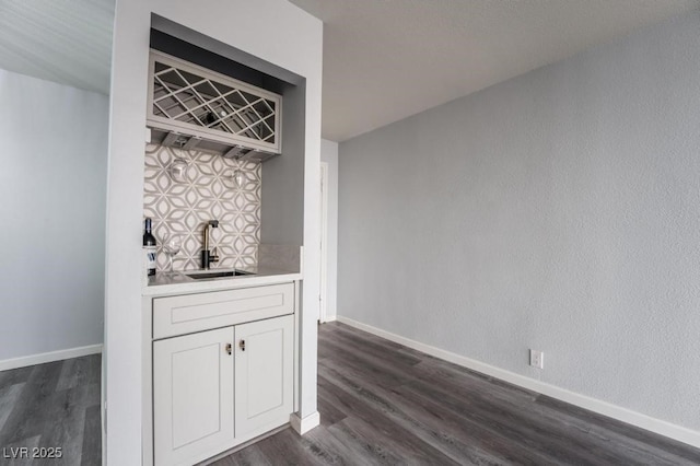 745 N Royal Crest Cir Unit 141, Las Vegas, NV 89169 - indoor wet bar featuring dark wood-style floors, baseboards, and backsplash