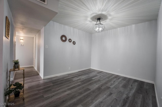 745 N Royal Crest Cir Unit 141, Las Vegas, NV 89169 - empty room featuring dark wood-style flooring, a chandelier, and baseboards