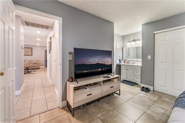 living room featuring light tile patterned floors, baseboards, recessed lighting, and a textured ceiling