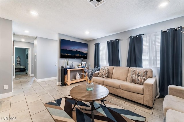 living room featuring light tile patterned floors, a textured ceiling, recessed lighting, and baseboards