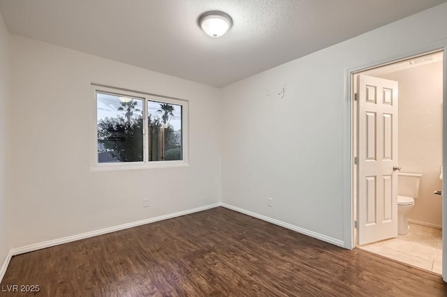 unfurnished room with wood finished floors and baseboards