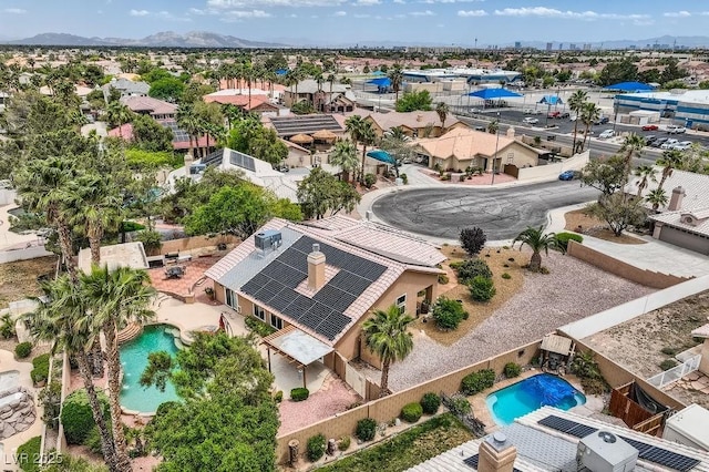 aerial view of property and surrounding area with a pool area and mountains