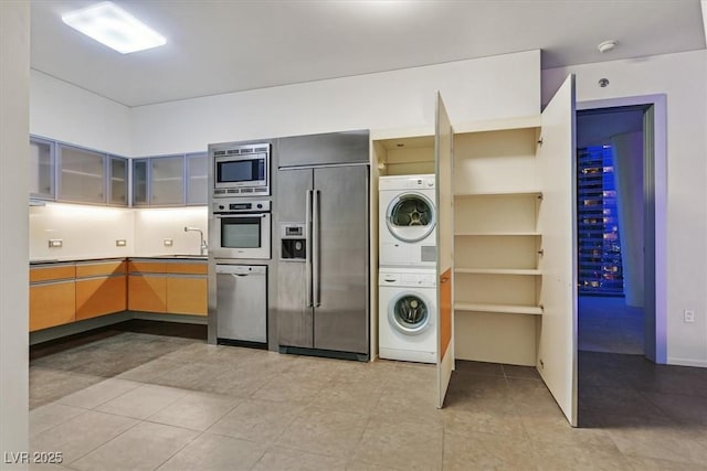 3726 Las Vegas Blvd Unit 1902, Las Vegas, NV 89158 - kitchen with built in appliances, stacked washing machine and dryer, a sink, glass insert cabinets, and light tile patterned floors