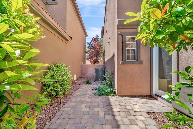 2432 Granada Bluff Ct, Las Vegas, NV 89135 - view of side of home featuring stucco siding, cooling unit, a patio area, and fence